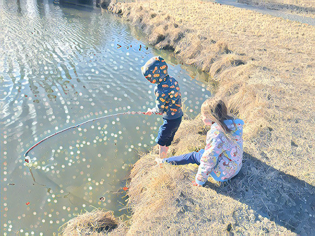 Unstructured play. Two kids fish in a pond using a stick. 